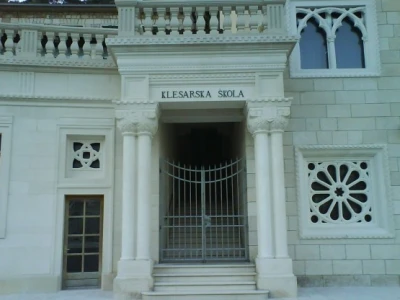 Klesarska škola u Pučišćima (ulazna vrata zagrljena stupovima, rozetama...)